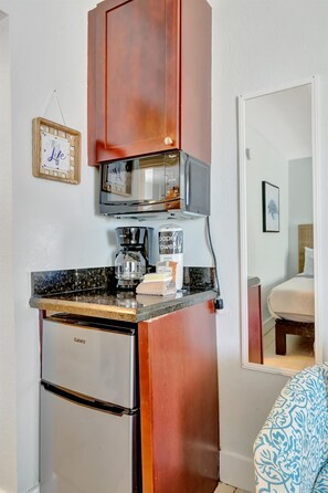 Une petite cuisine équipée comprenant un réfrigérateur Galanz, une machine à café et un four à micro-ondes.