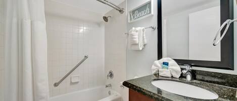 A bathroom with a bathtub, toilet, and sink.