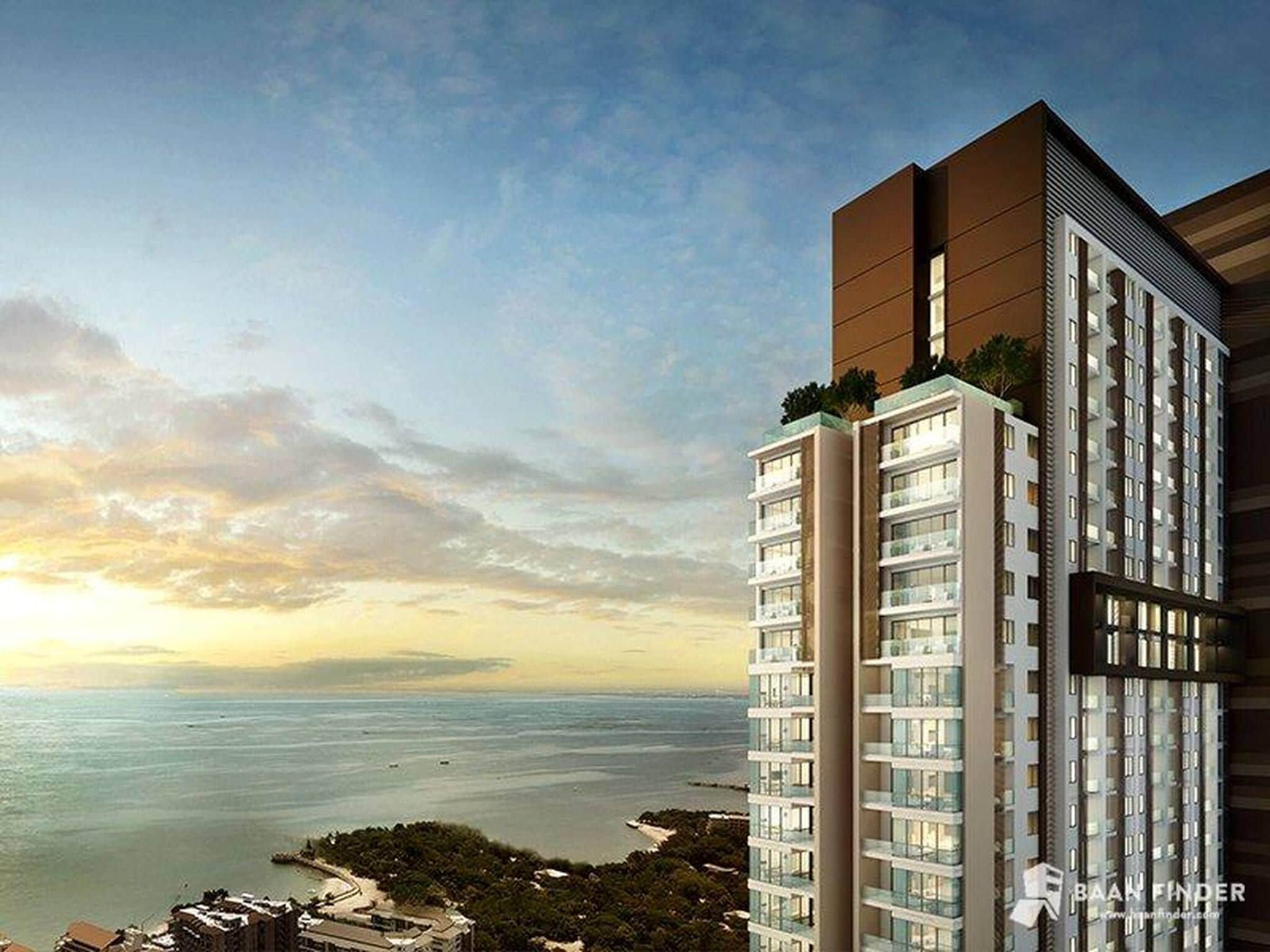 A high-rise building with multiple floors, large windows, and a view of the sea.