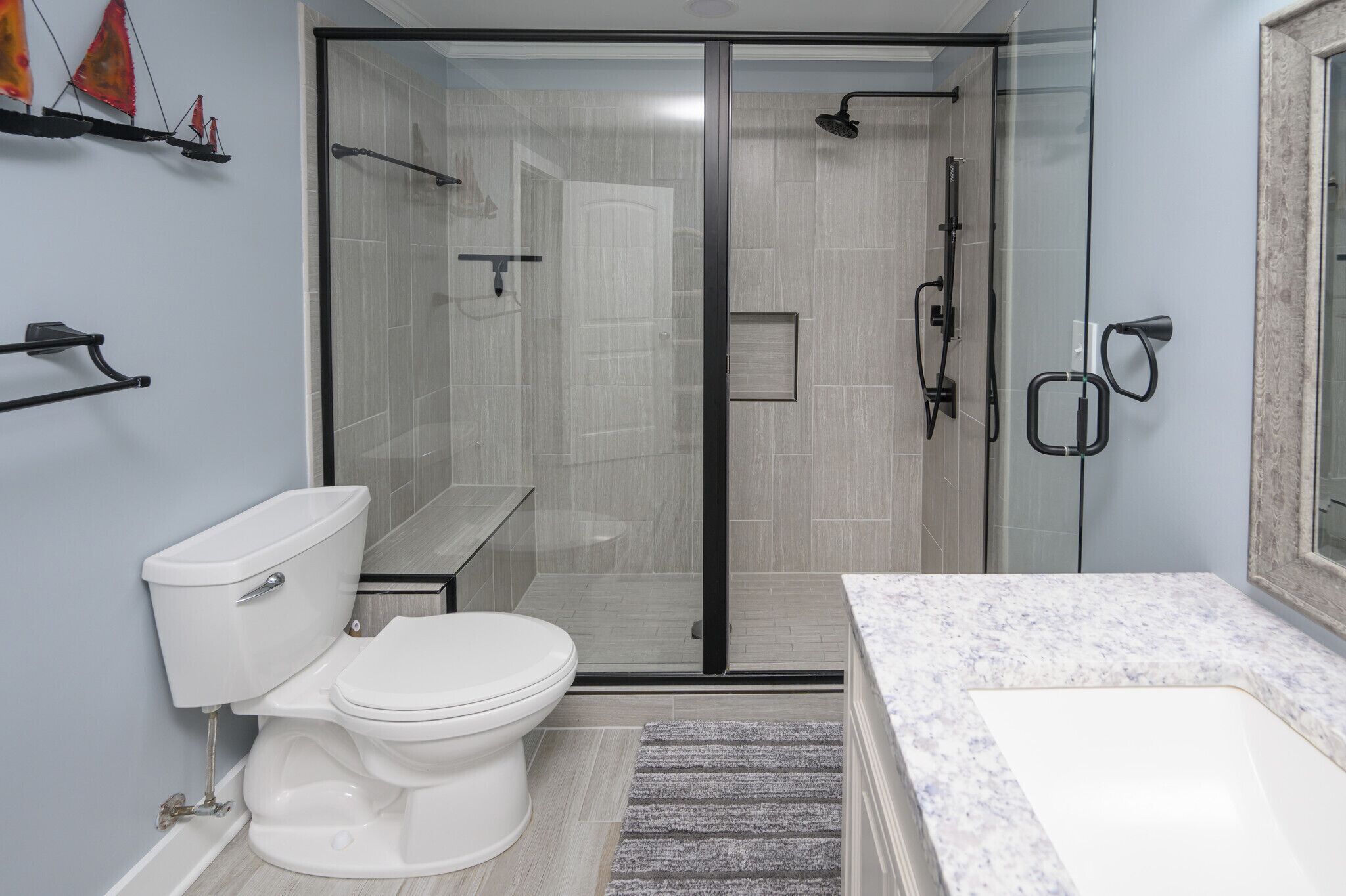 Uma casa de banho moderna com sanita, chuveiro e lavatório.