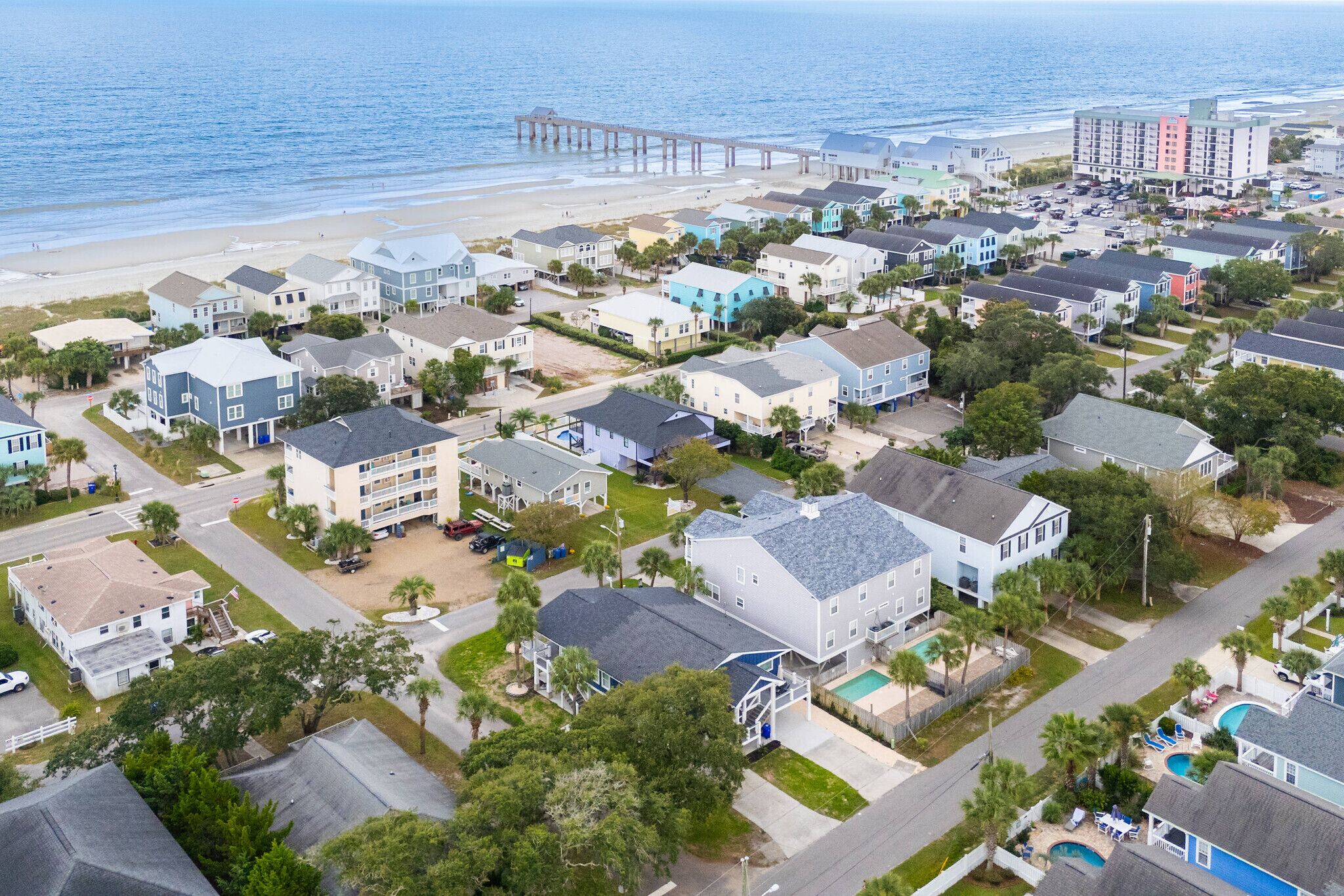 A coastal residential area with houses, a pier, and a hotel.