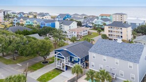 A coastal residential area with multiple two-story houses, some with balconies, and a view of the ocean. - Renovated, 3 Bedroom Beach House - Sun Dog (Surfside Beach)