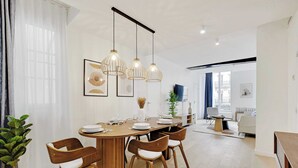 Un espace repas moderne avec une table en bois, quatre chaises et des lampes suspendues.