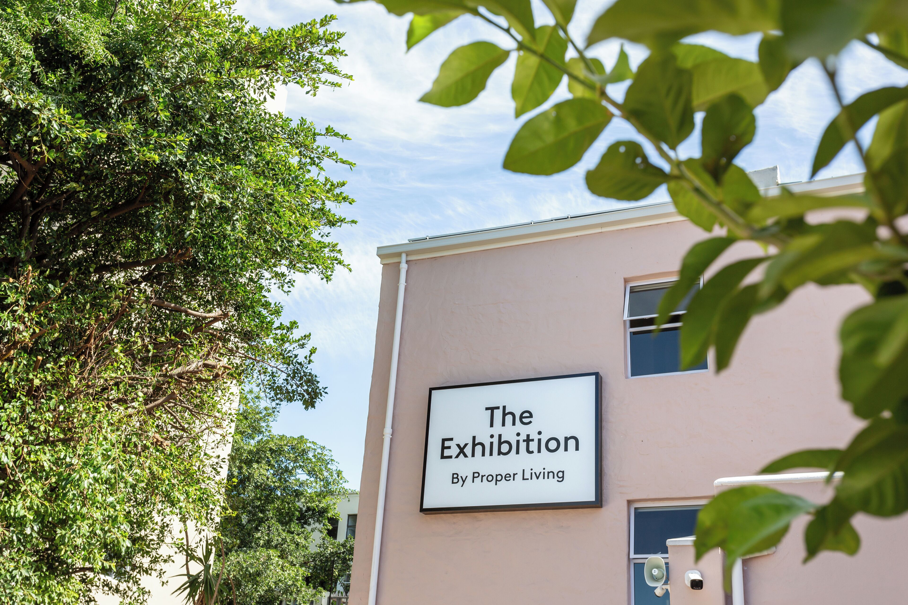 Un edificio con un cartello che riporta la scritta 'The Exhibition By Proper Living'.