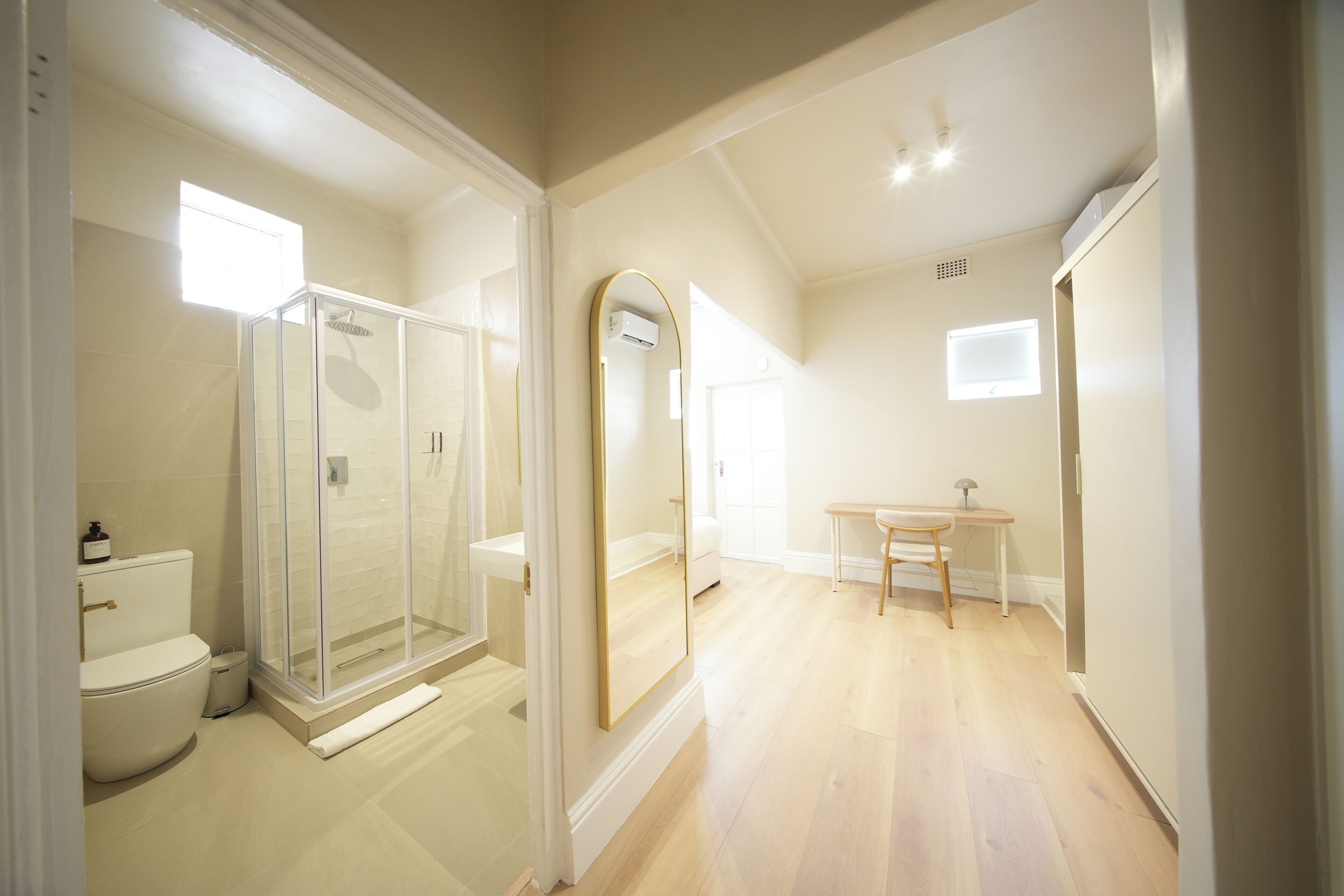 A bathroom with a toilet, shower, and sink.