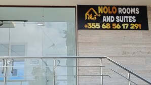 Segnale per "Nolo Rooms and Suites" con un numero di telefono.