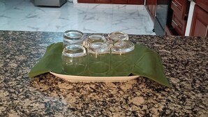 Eine Küche mit Holzausstattung, einem Edelstahlkühlschrank, einer Spüle und einer Arbeitsplatte aus Granit.