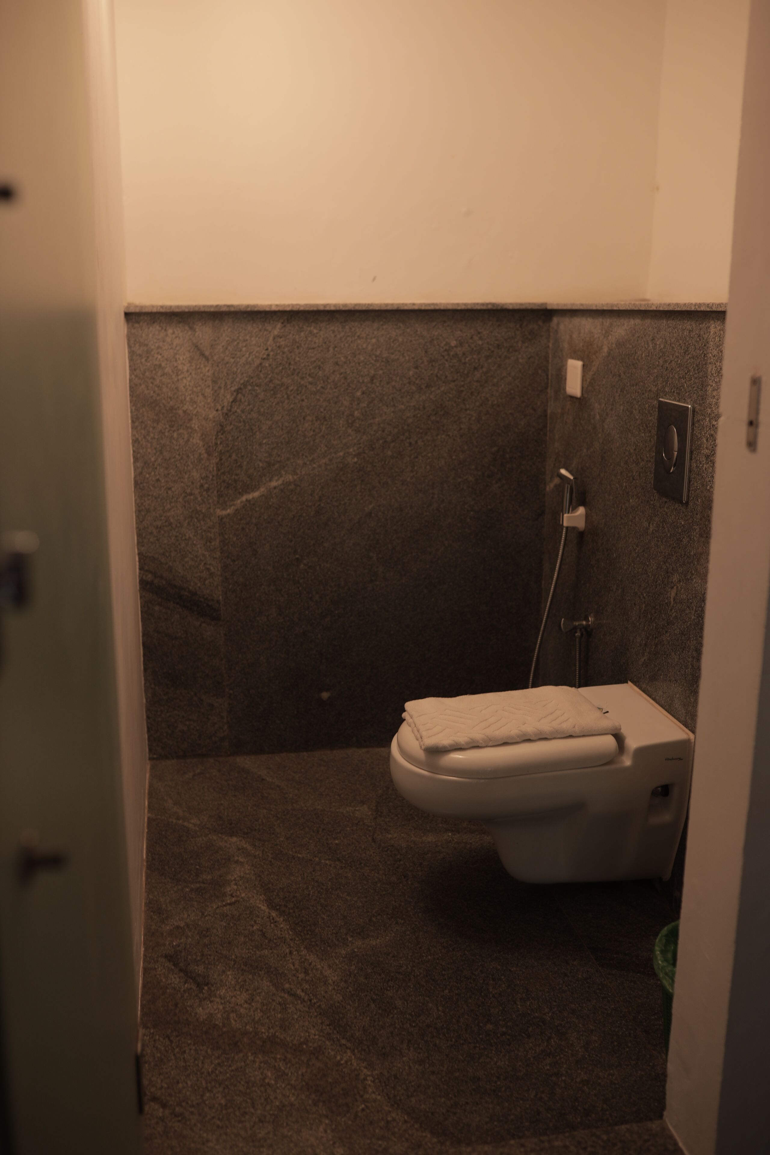 A small, dimly lit bathroom with a toilet and a shower stall.