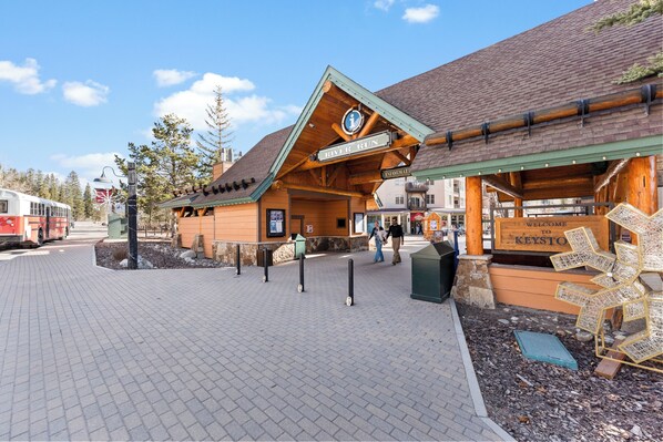 Un chalet à l’extérieur en bois, une enseigne indiquant « River Run », et un panneau d’accueil pour Keystone.