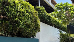 A building with a thatched roof, a balcony, and a white wall. - Villa JuPITER, Boracay, ocean view holiday home with pool (Malay)