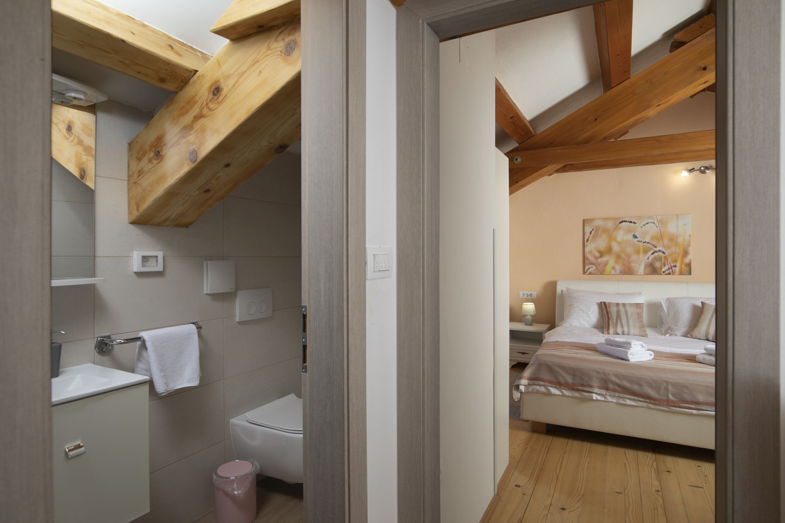 A bedroom with a bed, a nightstand, and a painting on the wall.