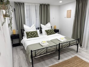 Une chambre d’hôtel bien rangée, avec un lit, deux tables de chevet, une lampe de chevet et un petit tableau décoratif accroché au mur.