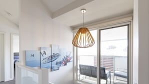 A staircase with a glass railing, a hanging pendant light, and artwork on the wall. - Modern 3BR Executive Townhouse in CBD, Mibnb (Geelong)