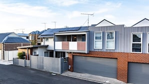A residential area with modern houses, a garage, and a street. - Modern 3BR Executive Townhouse in CBD, Mibnb (Geelong)