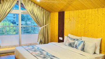 Un dormitorio amplio con una cama grande, techo de madera y vistas al exterior.
