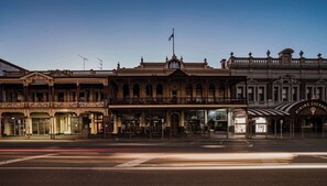 Un edificio histórico con arquitectura ornamentada, que incluye balcones y barandillas decorativas.