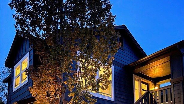 A two-story house with a wooden staircase and a tree in front. - Bluebird Day - Summit Sanctuary: Perfect for a romantic getaway. (Bend)