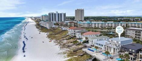 Ett hotell vid stranden med flera byggnader, en sandstrand och en fri utsikt över havet.