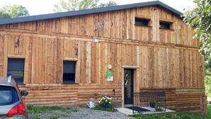 A wooden building with a door, windows, and a sign.