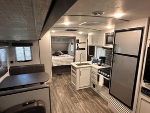 Cocina compacta para autocaravana con refrigerador, estufa, microondas y pileta.