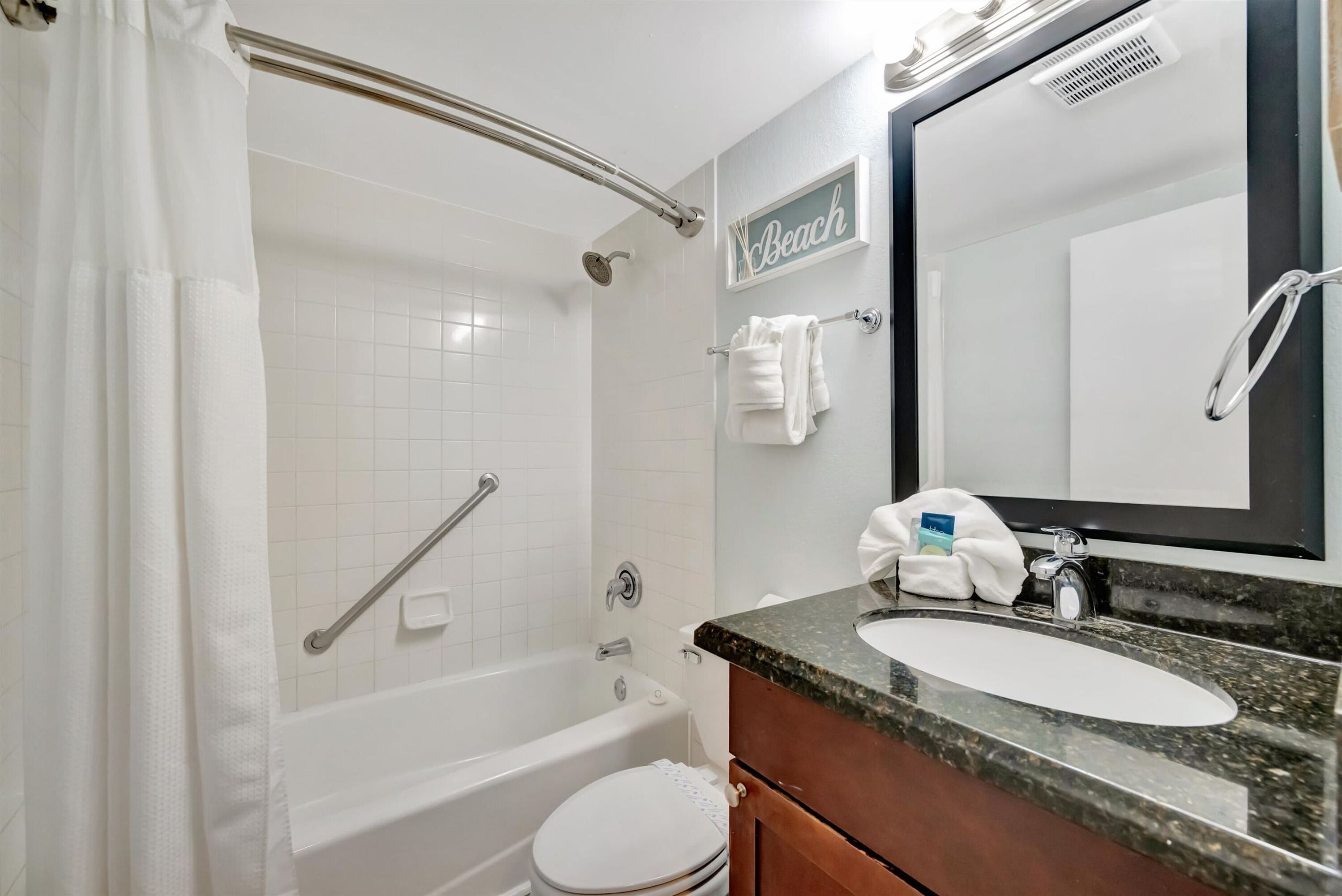 A bathroom with a bathtub, toilet, and sink.