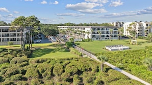 A modern hotel complex with multiple buildings, a parking area, and well-maintained green spaces. - Island Condo for 6 w Communal Pool - Perfect Spot! (Hilton Head Island)