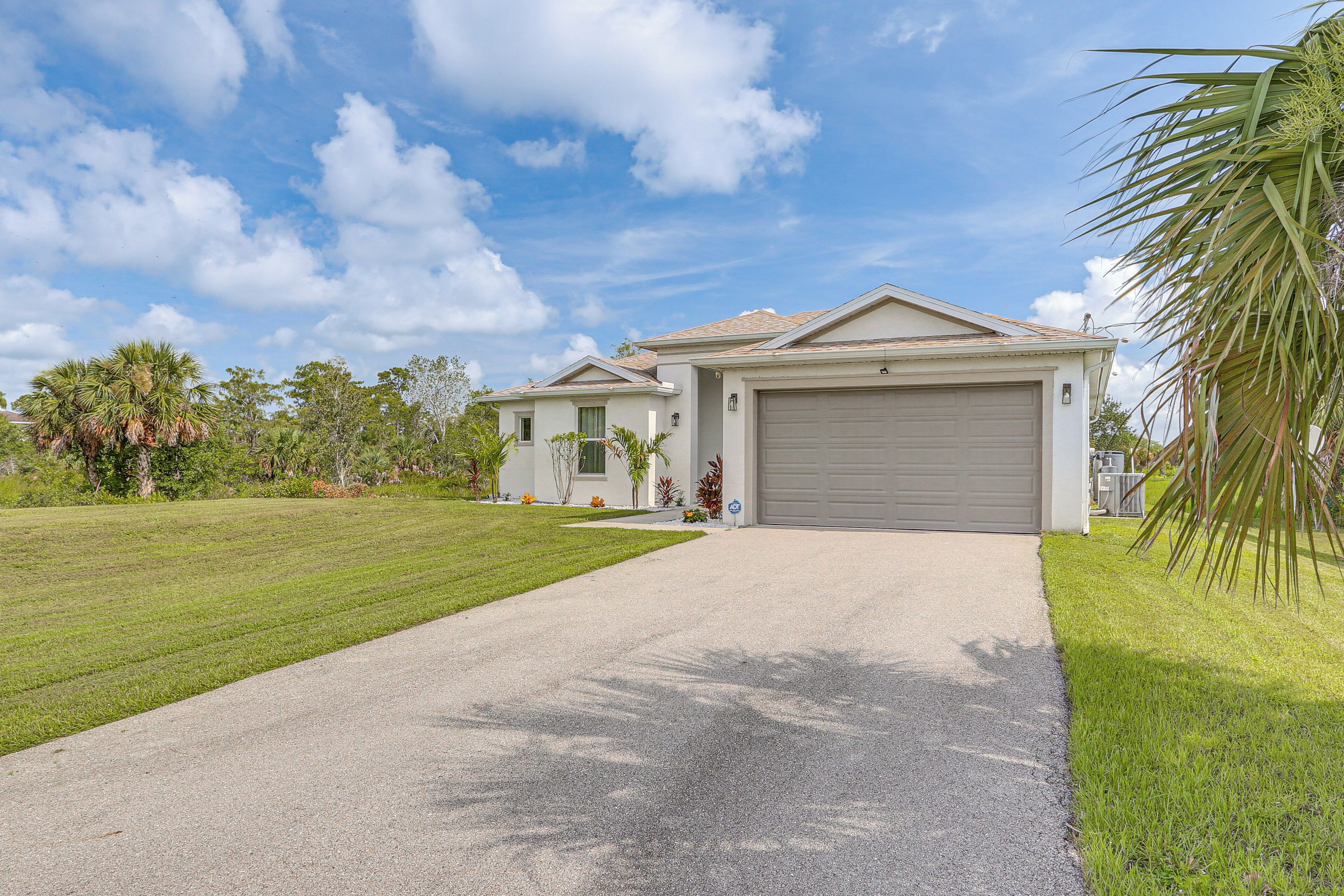 A two-story house with a driveway leading to a garage.
