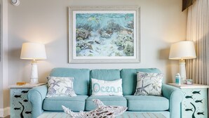 Un sofá color turquesa con tres almohadas, una de ellas con la etiqueta 'Ocean'.