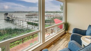 A room with large windows overlooking a dock and water.