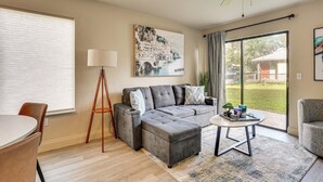 Ein Wohnzimmer mit einer Eckcouch, einem runden Couchtisch und einer Stehlampe.