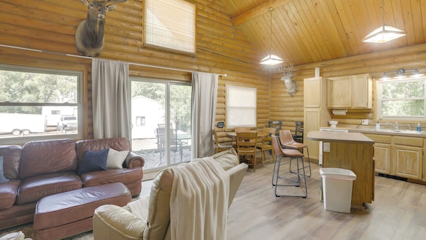 Une cabane en rondins comprenant un salon, un coin repas et une cuisine.