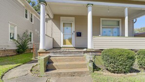A two-story house with a front porch, a set of stone steps leading to the door, and a small garden area with a bush. - 1 Mi to Dtwn & Franciscan University: Home w/ Yard (Steubenville)
