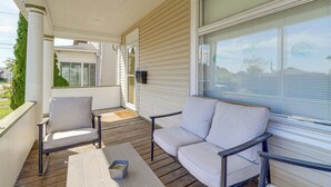 A covered porch with two chairs and a table, wooden flooring, and large windows with blinds. - 1 Mi to Dtwn & Franciscan University: Home w/ Yard (Steubenville)