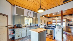 Une cuisine avec un plafond en bois, un îlot central et des appareils électroménagers intégrés.