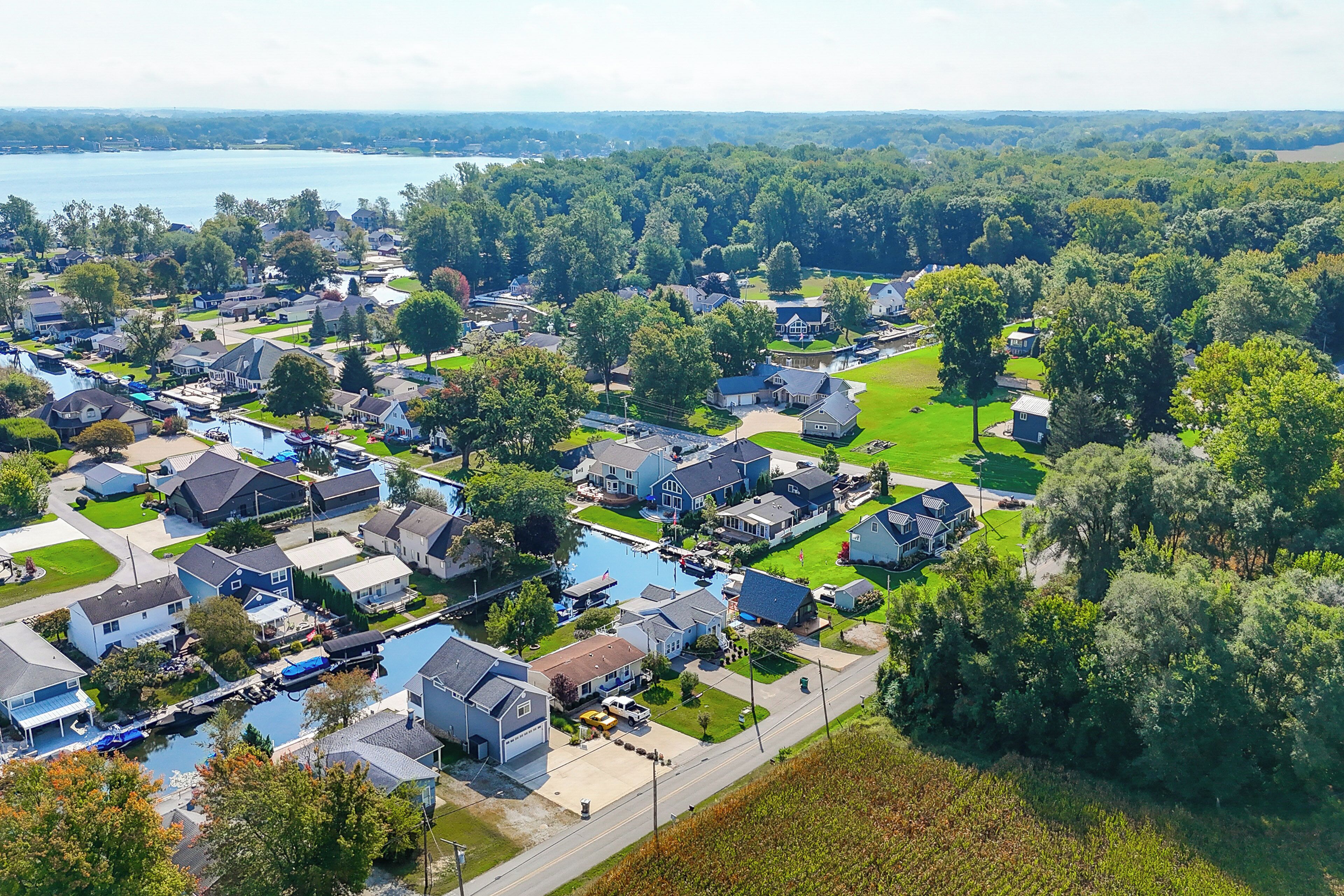 An aerial view of a residential area with houses, a small body of water, and a park.