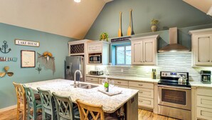 A kitchen with a central island, wooden chairs, a stainless steel oven, and a microwave. - 'tookies Retreat' Walk to Mairina! Home w/ Hot Tub (Smithville)
