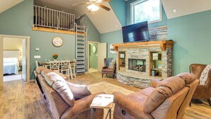 A spacious living room with a stone fireplace, leather sofas, a TV, and a wooden ceiling fan. - 'tookies Retreat' Walk to Mairina! Home w/ Hot Tub (Smithville)