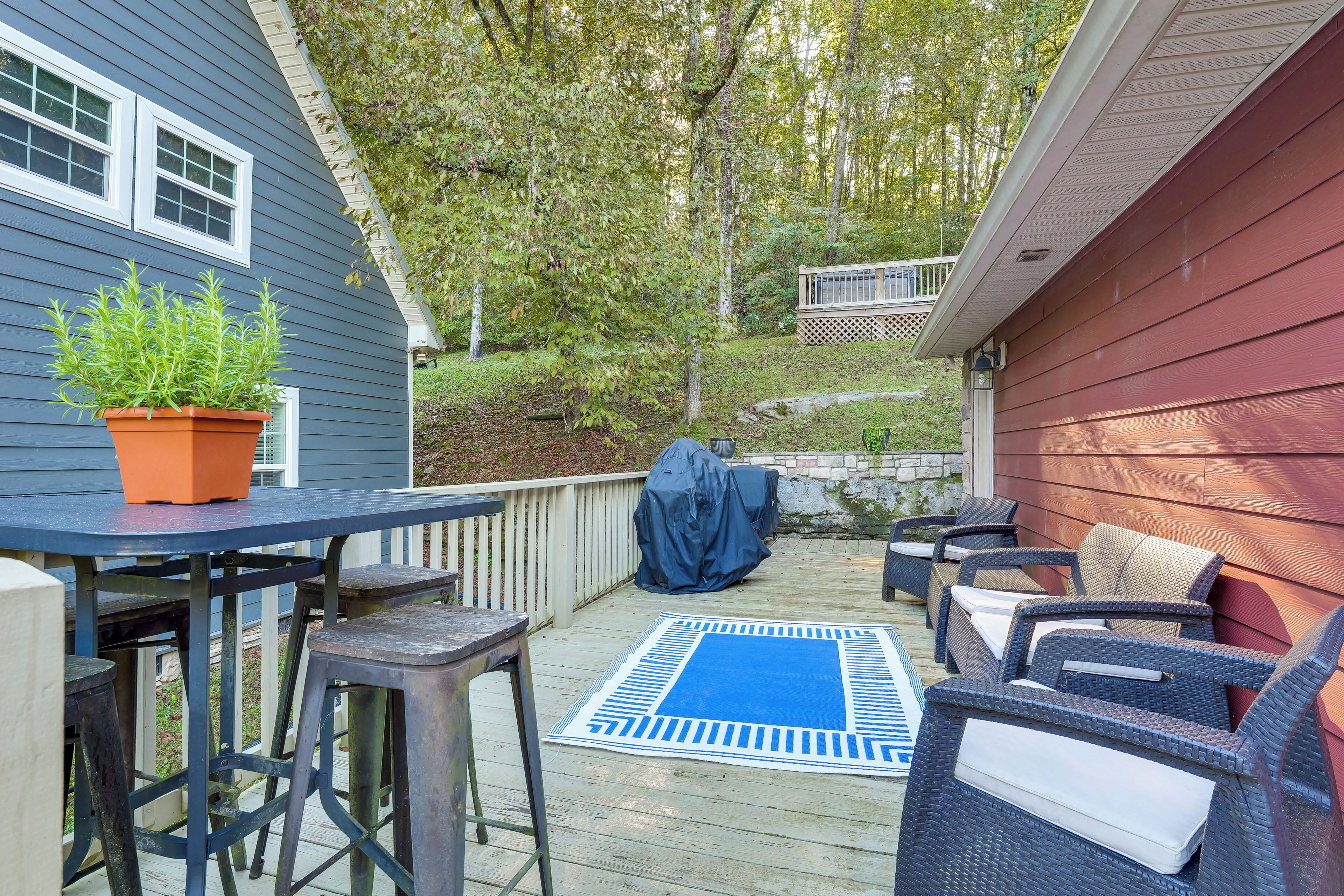 Een terras met buitenmeubilair, een overdekte barbecue en een bloempot.