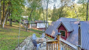 A rustic cabin with a stone fire pit, outdoor seating, and a wooden deck. - 'tookies Retreat' Walk to Mairina! Home w/ Hot Tub (Smithville)