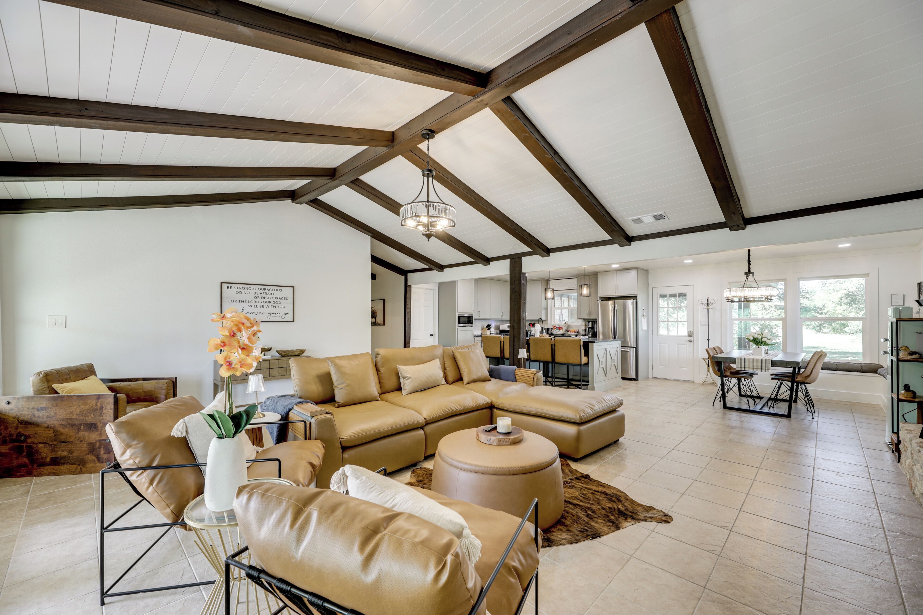 A spacious living room with a large sectional sofa, a coffee table, and a dining area with a table and chairs.