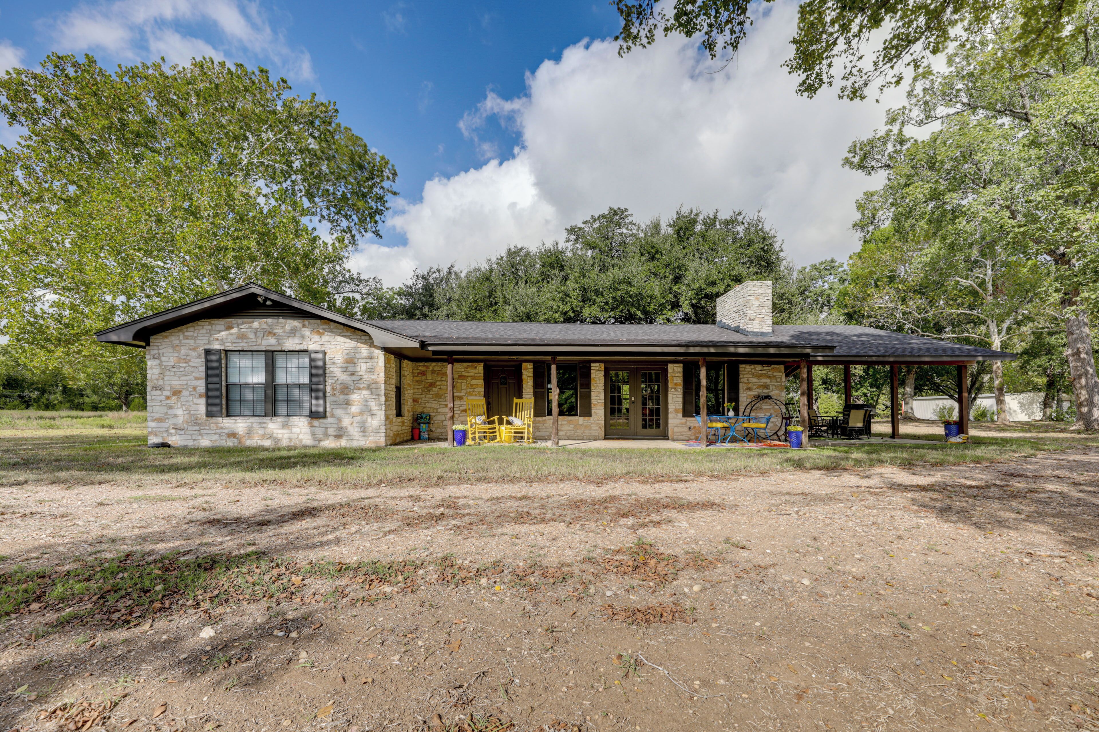 A stone building with a covered porch and outdoor seating.