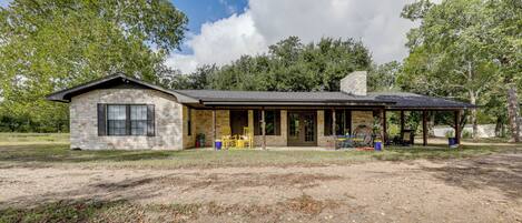 A stone building with a covered porch and outdoor seating.