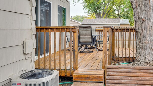 A deck with a table and chairs, a wooden fence, and a tree. - Walk to Parks & Greenway: Sioux Falls Getaway! (Sioux Falls)