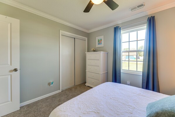 A bedroom with a bed, a dresser, a closet, and a window with curtains. - 7 Mi to the Hammocks Beach: 3 BD Near Camp Lejeune (Hubert)