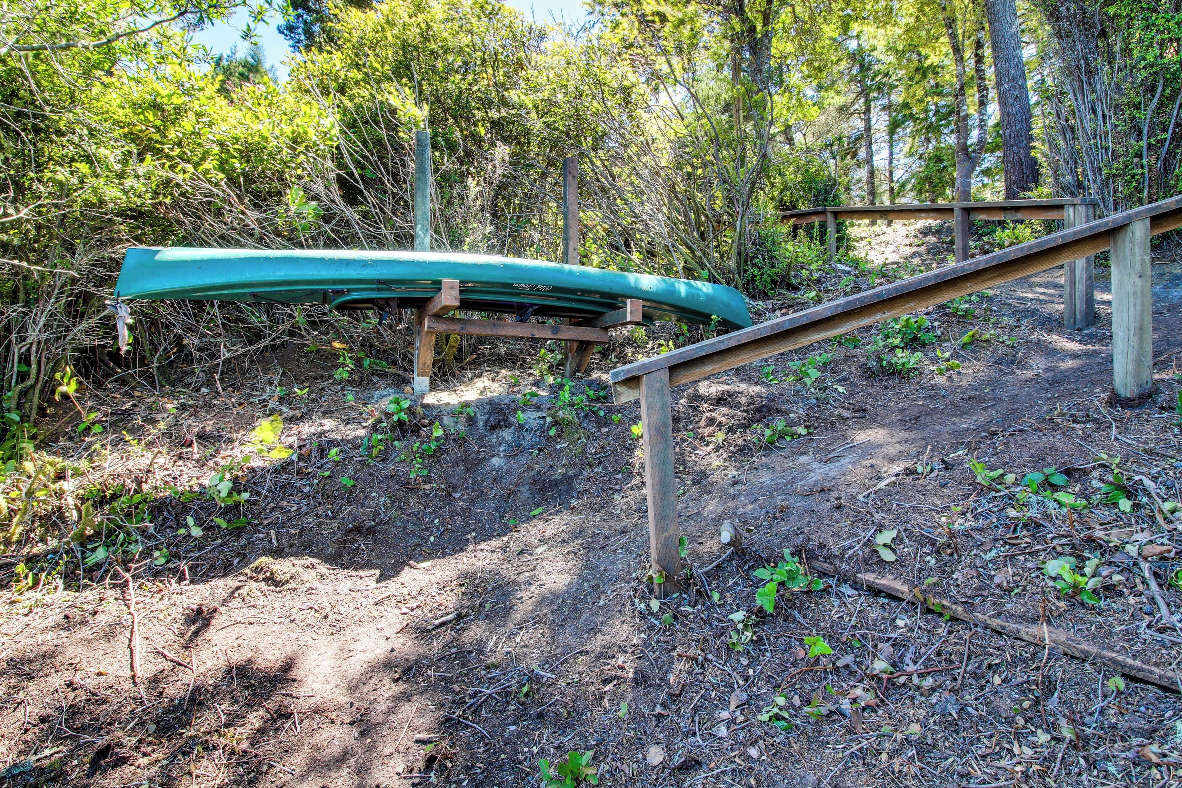 A canoe on a wooden stand in a wooded area.