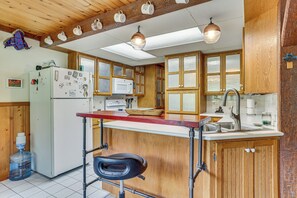 A kitchen with wooden cabinets, a refrigerator, a microwave, and a sink. - Near Mississippi River! Countryside Family Retreat (Eastman)