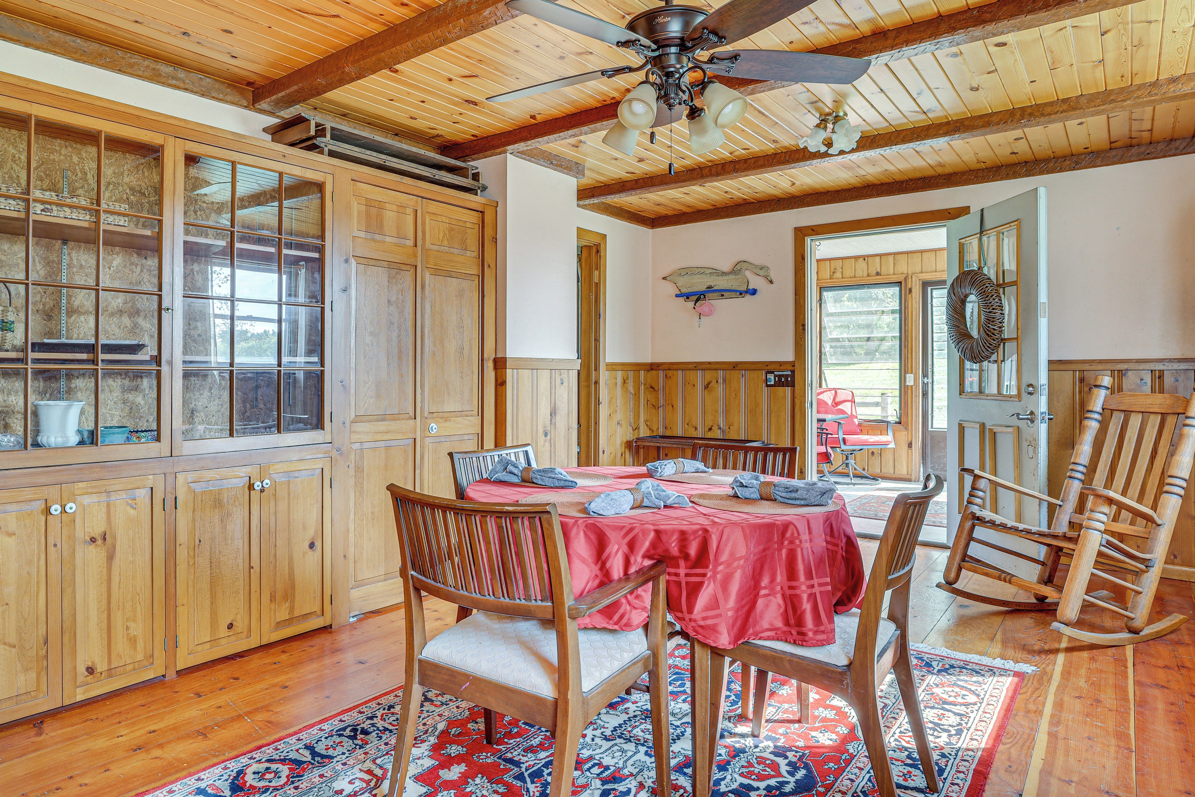 A dining area with a wooden table, chairs, and a ceiling fan.