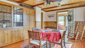 A dining area with a wooden table, chairs, and a ceiling fan.