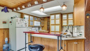 A kitchen with wooden cabinets, a refrigerator, a microwave, and a sink. - Near Mississippi River! Countryside Family Retreat (Eastman)