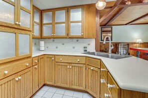 A kitchen with wooden cabinets, a white countertop, and a stainless steel sink. - Near Mississippi River! Countryside Family Retreat (Eastman)